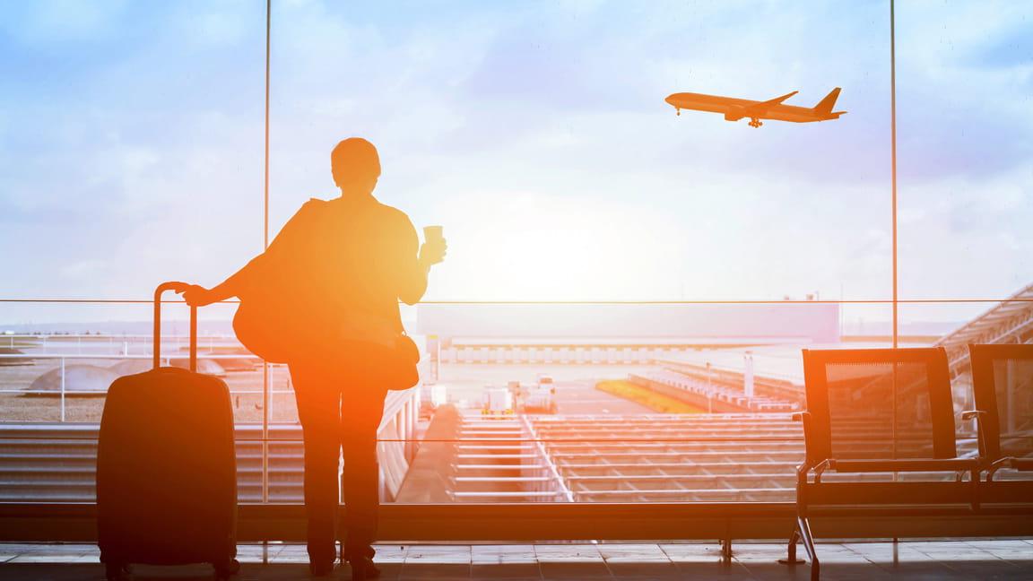 silhouetted woman traveler waiting for airplane to land